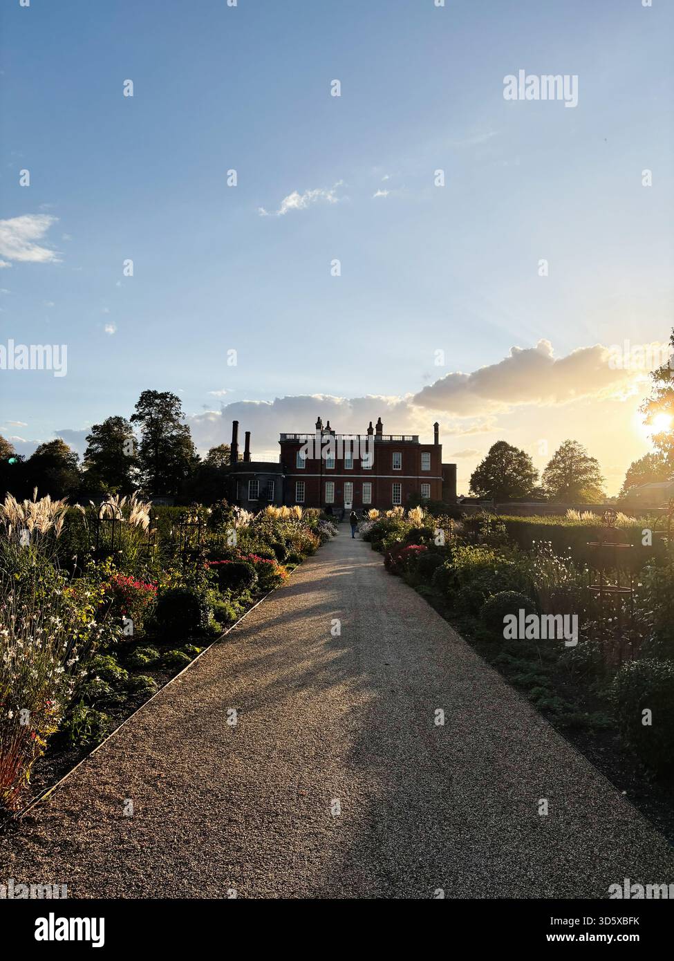 Londra, Regno Unito - 22 settembre 2025: Maestosa residenza Ranger's House in mattoni rossi con giardino formale, sentiero di ghiaia e tramonto dorato a Londra. Foto Stock