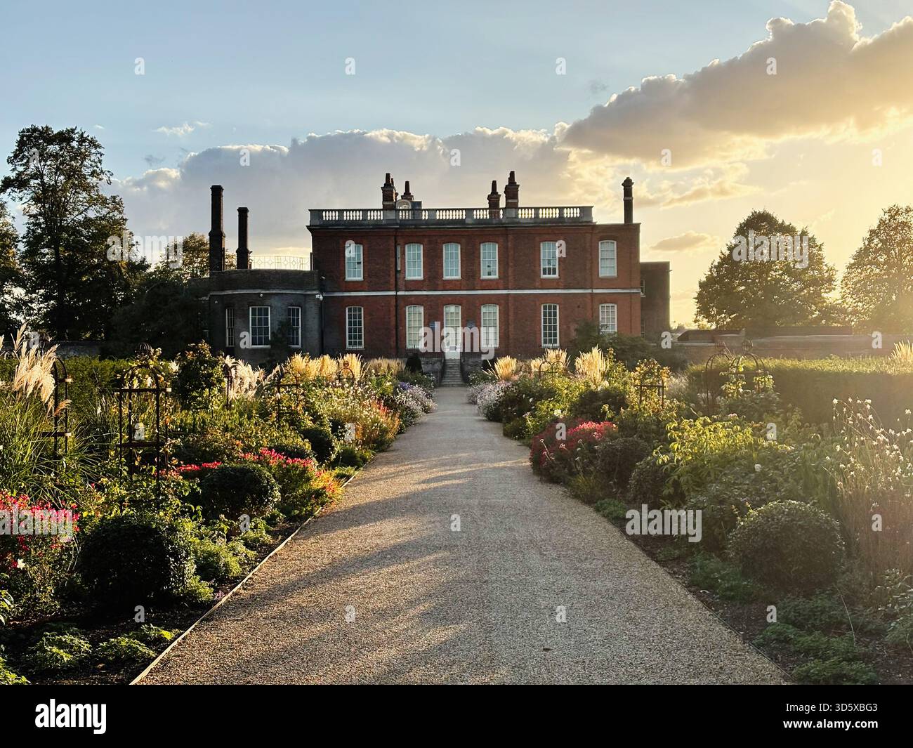 Londra, Regno Unito - 22 settembre 2025: Il sentiero del giardino illuminato dal sole conduce a una maestosa casa padronale in mattoni Ranger's House a Londra, Regno Unito. Foto Stock