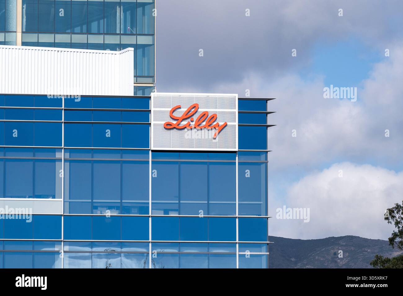 Logo Eli Lilly sulla facciata del moderno edificio di vetro con cielo parzialmente nuvoloso, South San Francisco, California, 16 ottobre 2025. (Foto di Smith Collection/Gado/Sipa USA) Foto Stock