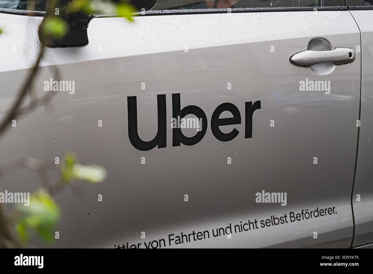 Primo piano di un veicolo Uber con l'audace logo nero sulla portiera Foto Stock