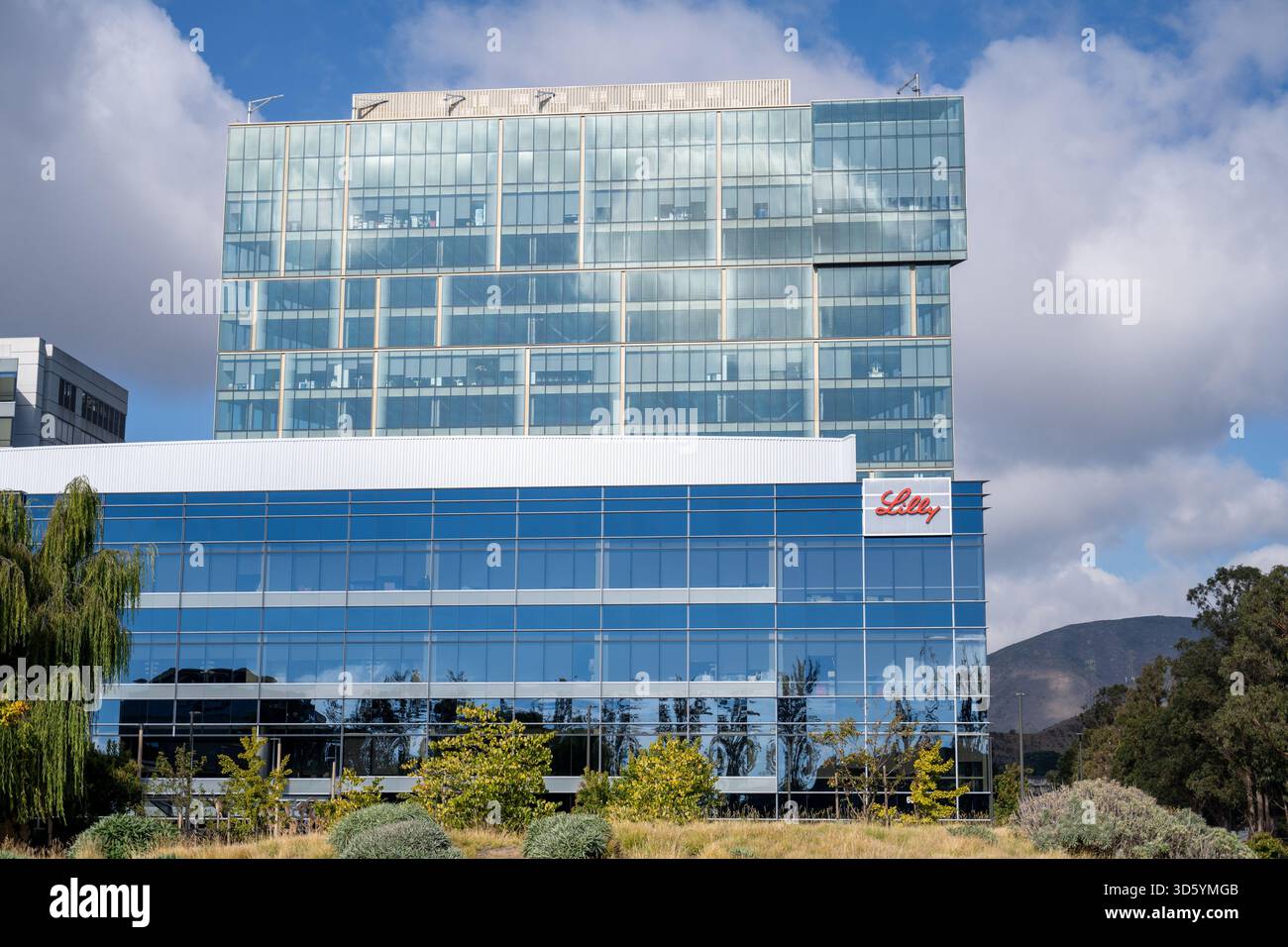 Logo Eli Lilly sulla facciata del moderno edificio di vetro con cielo parzialmente nuvoloso, South San Francisco, California, 16 ottobre 2025. (Foto di Smith Collection/Gado/Sipa USA) Foto Stock