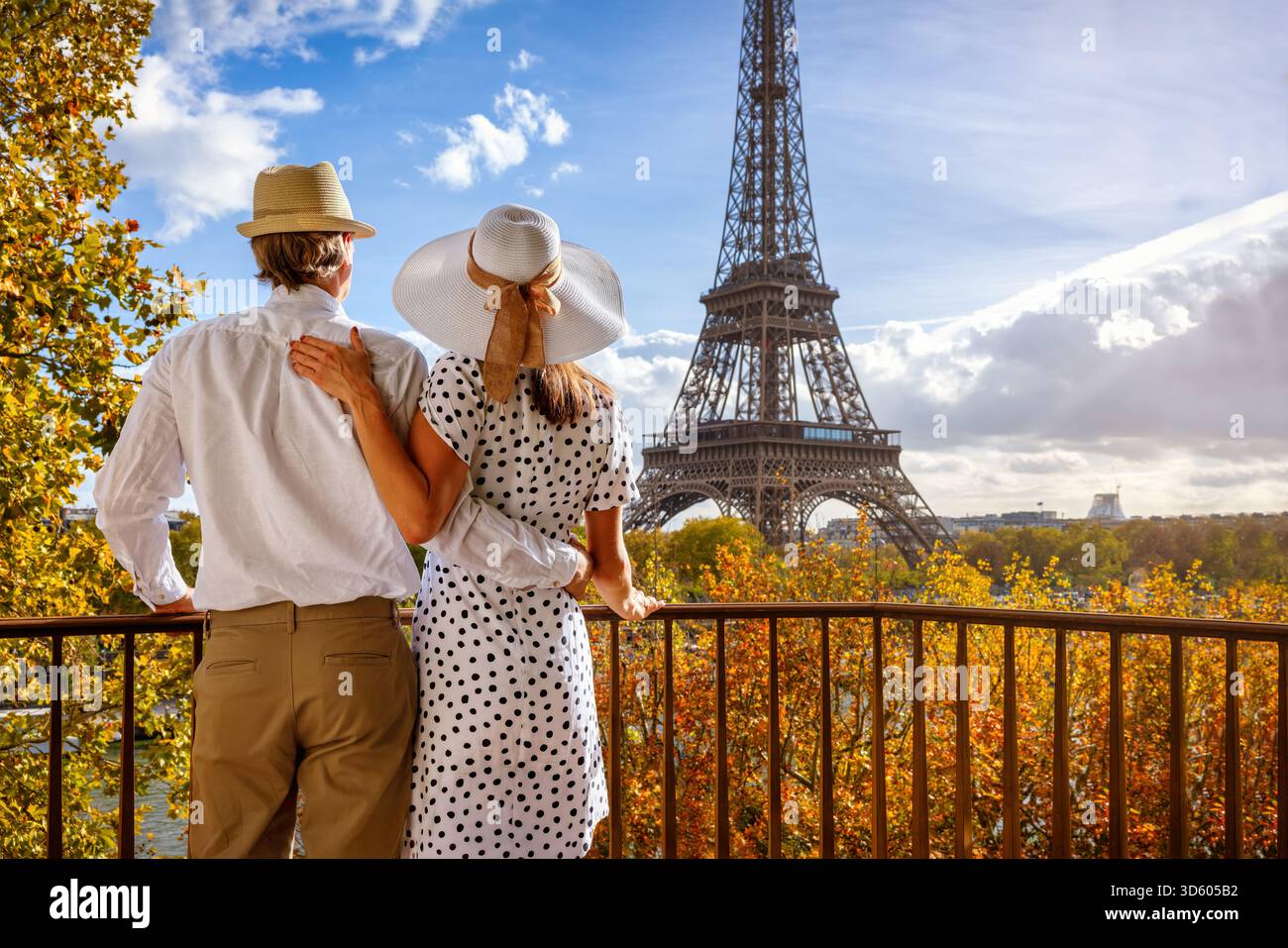 Romantico concetto di viaggio in città con un'elegante coppia di turisti che guarda la Torre Eiffel a Parigi, in Francia, dal loro balcone Foto Stock