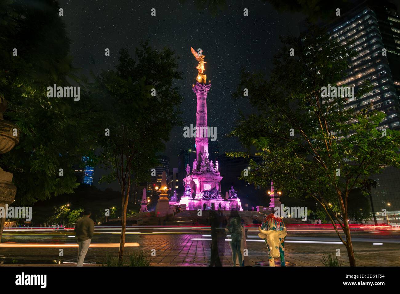 Foto a lunga esposizione dell'Angelo dell'indipendenza illuminata di notte su Reforma Avenue a città del Messico, con sentieri di luce, alberi e una clea Foto Stock