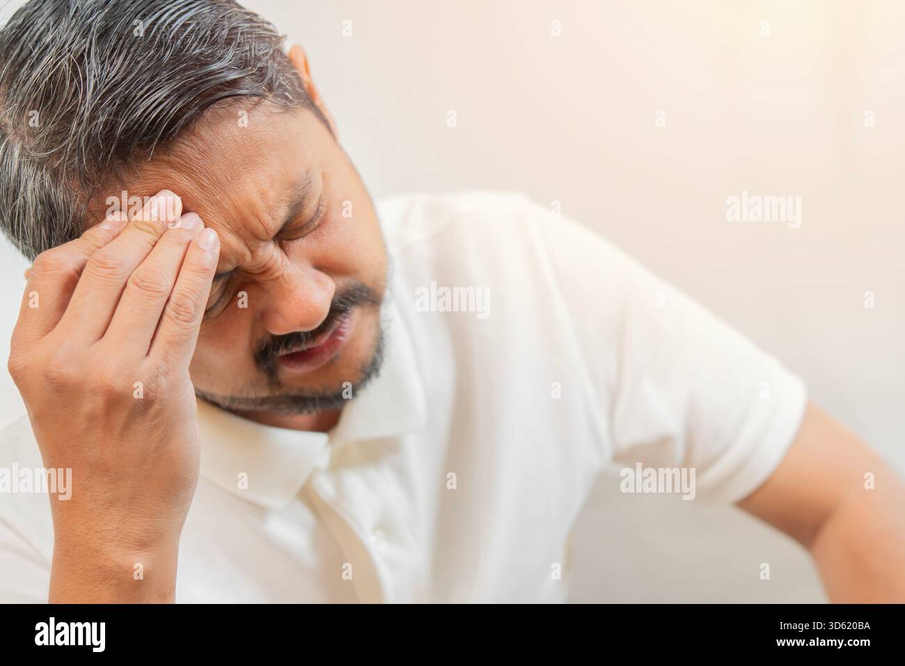 Mente, problema di salute e concetto di stress. Primo piano infelice asiatico che soffre di mal di testa su sfondo bianco Foto Stock