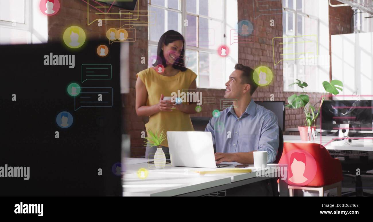 Colleghi parlanti che indossano camicia blu, camicetta gialla in ufficio aperto utilizzando laptop, tazza, mascherina per chat Foto Stock