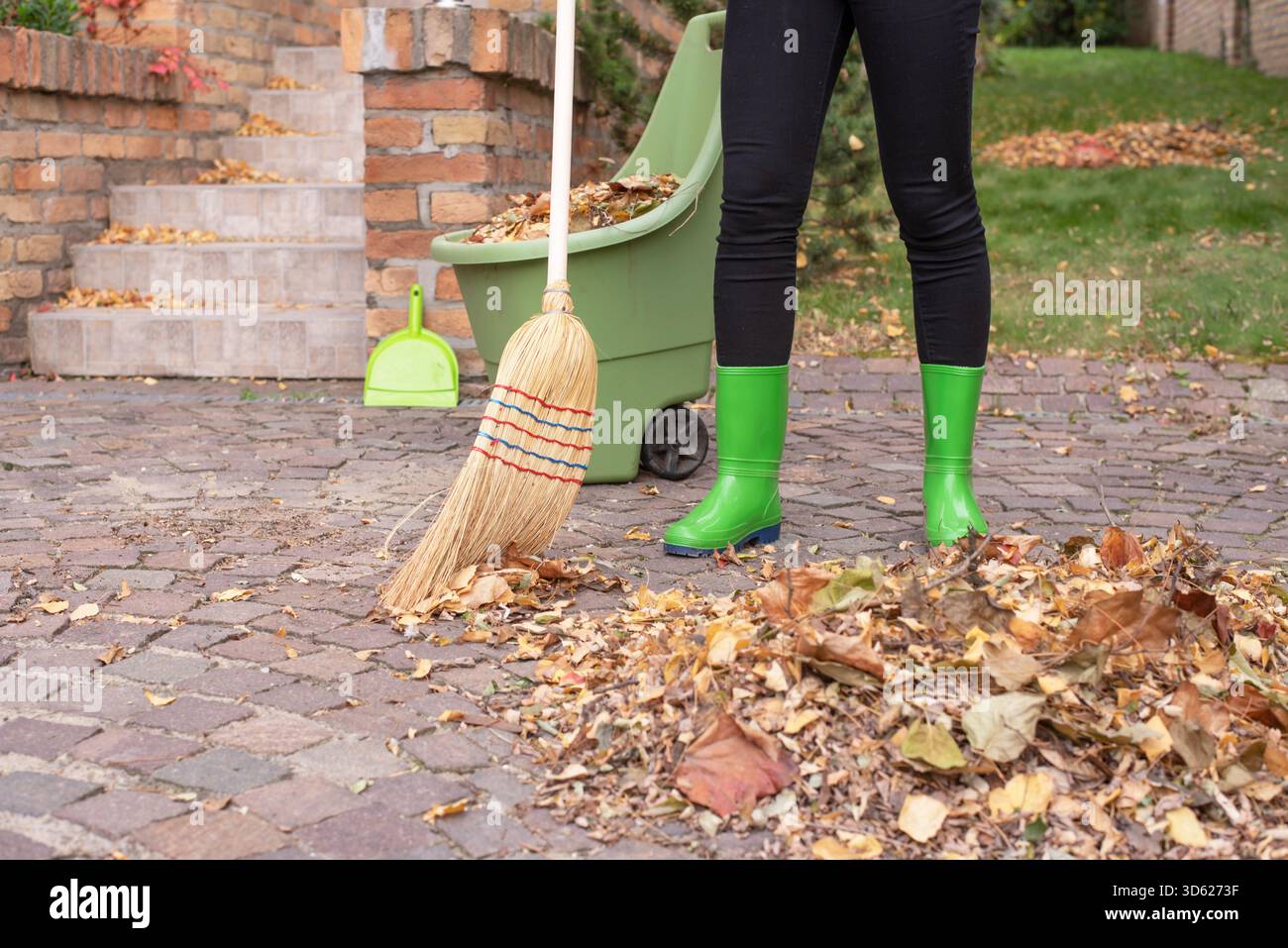 Il giardino autunnale funziona, rastrellare le foglie. Foto Stock