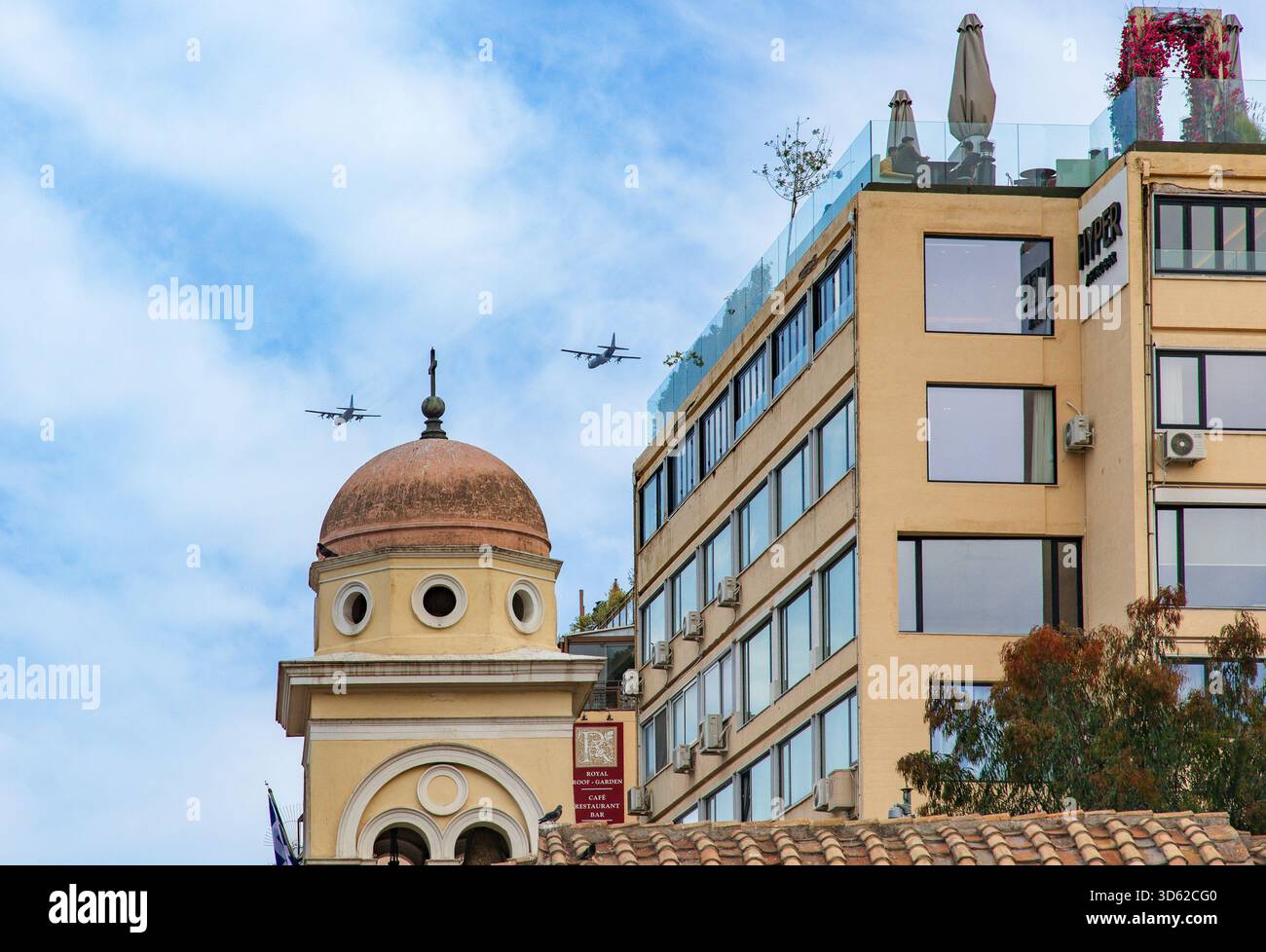 Due aerei da trasporto militari che volano sopra un edificio moderno ad Atene Foto Stock