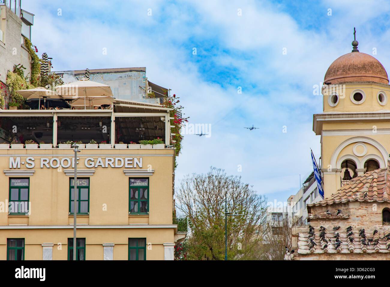 Due aerei da trasporto militari che volano sopra un edificio moderno ad Atene Foto Stock