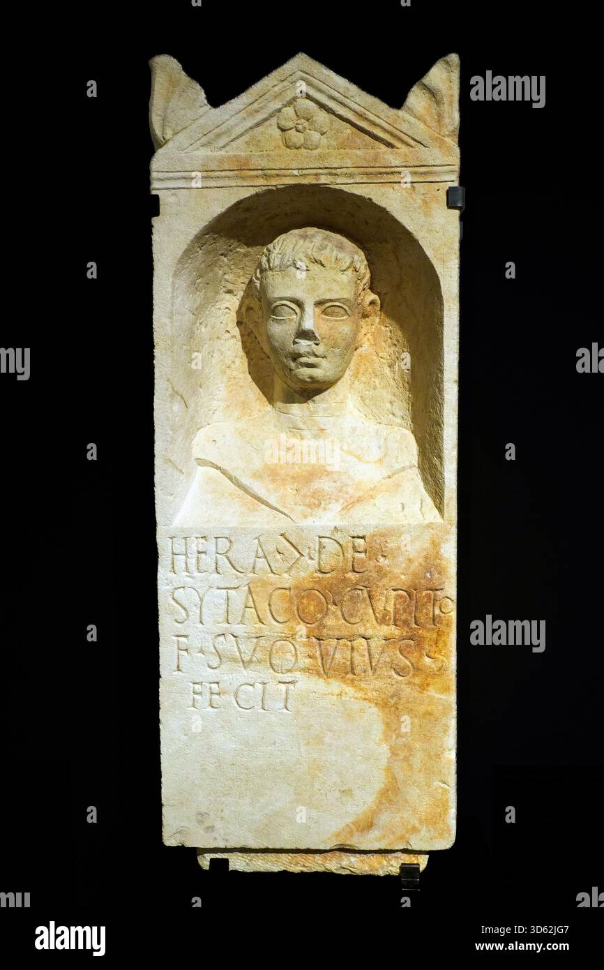 Stele funeraria dell'aedicula con tipo acroteria dedicata al figlio di un centurione della marina imperiale, il cui nome è Hera, molto probabilmente di origine greca. Il ritratto è quello di un giovane. II - III secolo d.C. - calcare - Museo della città e del territorio - Ravenna, Italia Foto Stock