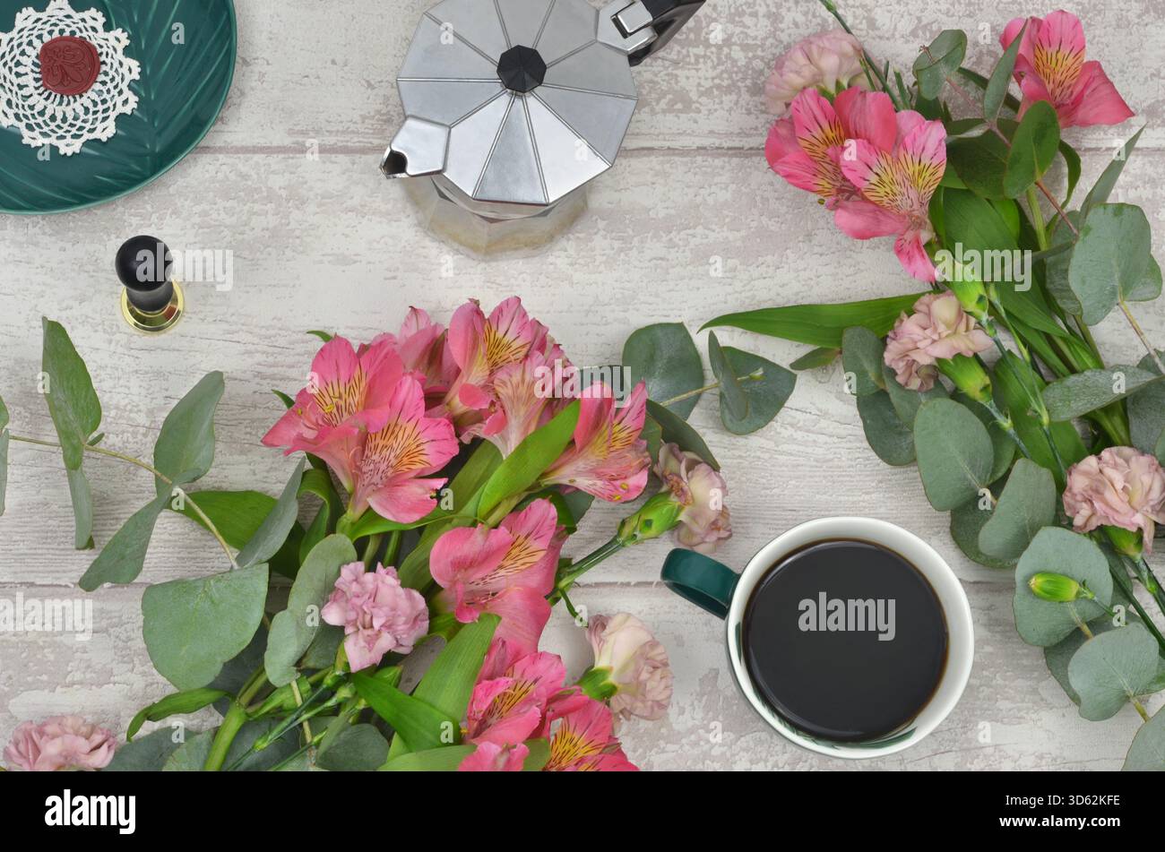 Caffè nero (americano) e fiori rosa, vista dall'alto tavolo in legno chiaro. Foto Stock