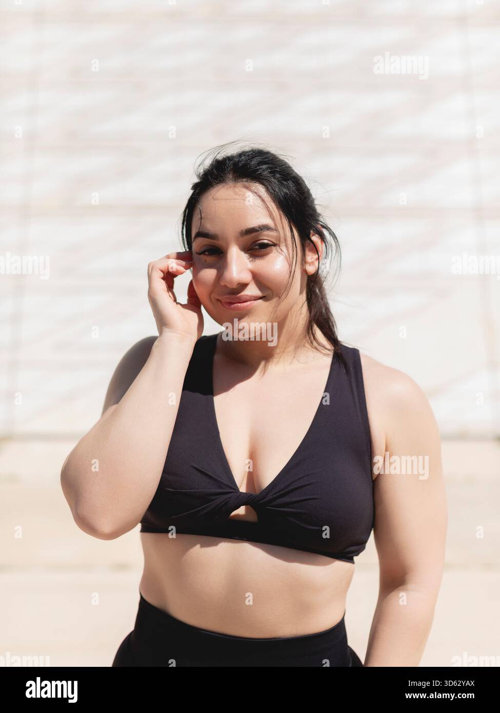 Ritratto naturale di una giovane donna con capelli neri lisci, felice, che guarda la fotocamera, dopo una sessione sportiva o di esercizio all'aperto Foto Stock