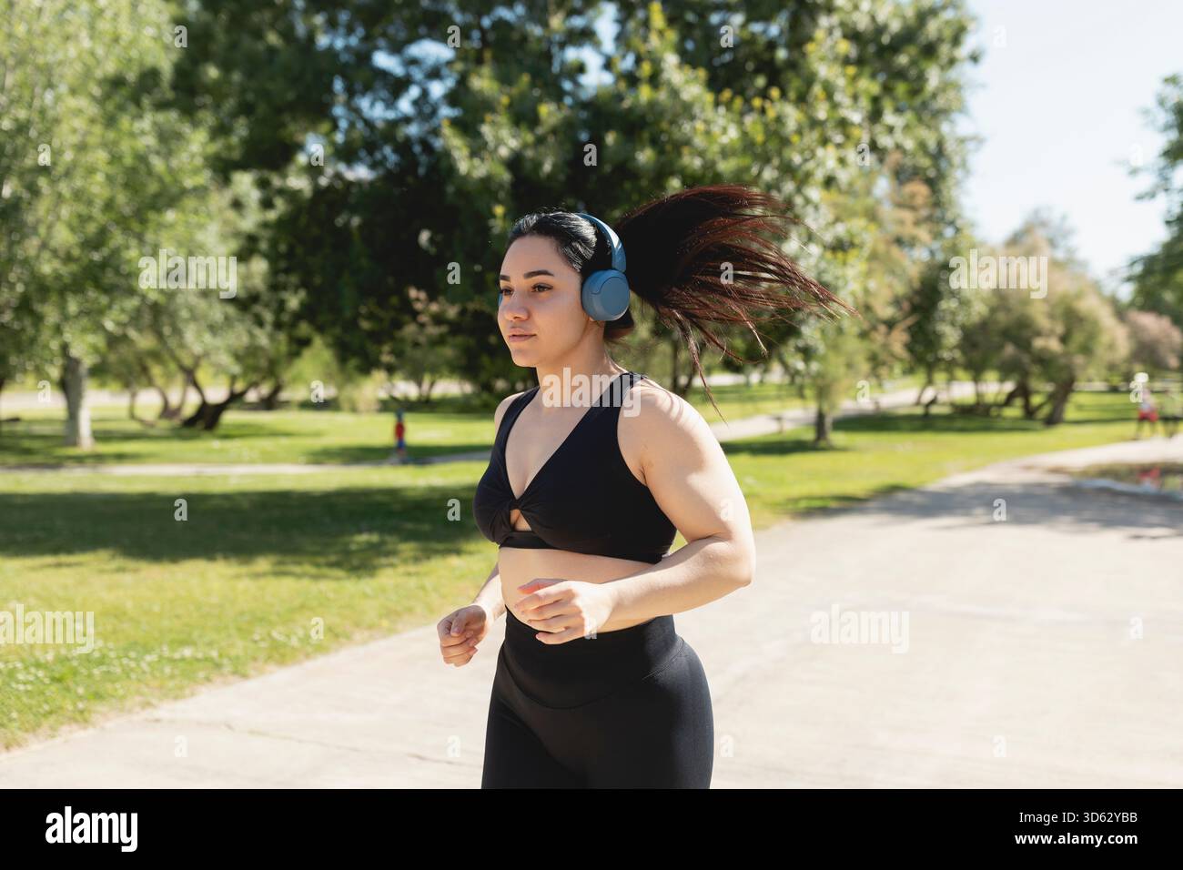 Una giovane donna che corre e si allena, mentre ascolta musica con le cuffie, Saragozza, Spagna Foto Stock