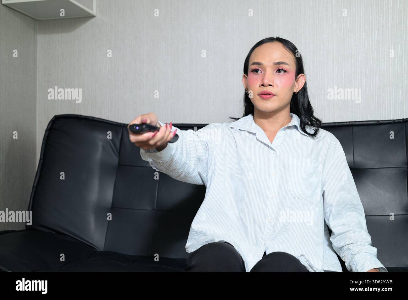 Ritratto di un giovane transgender thailandese con trucco e capelli lunghi. Concetto di espressione di genere, orgoglio LGBTQ e inclusività che mostra autententi Foto Stock