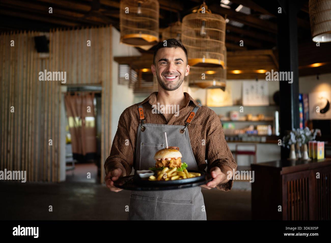 Caffè sicuro, proprietario di un ristorante in piedi con le braccia incrociate, che dà il benvenuto ai clienti al bar Foto Stock