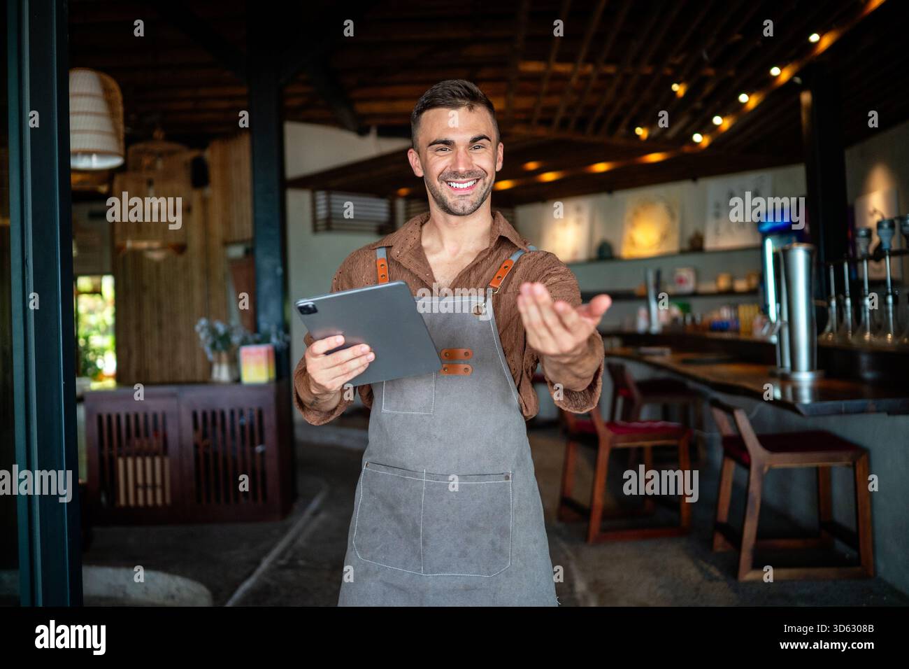 Caffè sicuro, proprietario di un ristorante in piedi con le braccia incrociate, che dà il benvenuto ai clienti al bar Foto Stock