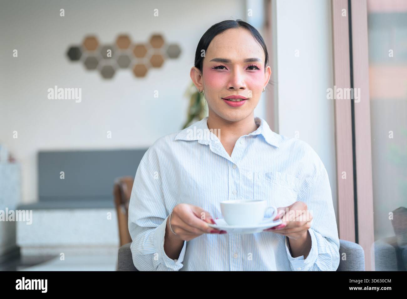 Ritratto di un giovane transgender thailandese con trucco e capelli lunghi. Concetto di espressione di genere, orgoglio LGBTQ e inclusività che mostra autententi Foto Stock