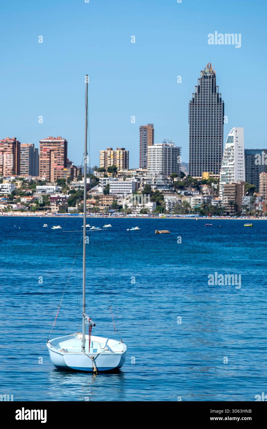 Barca a vela e vista dei grattacieli e della costa di Benidorm, Spagna Foto Stock