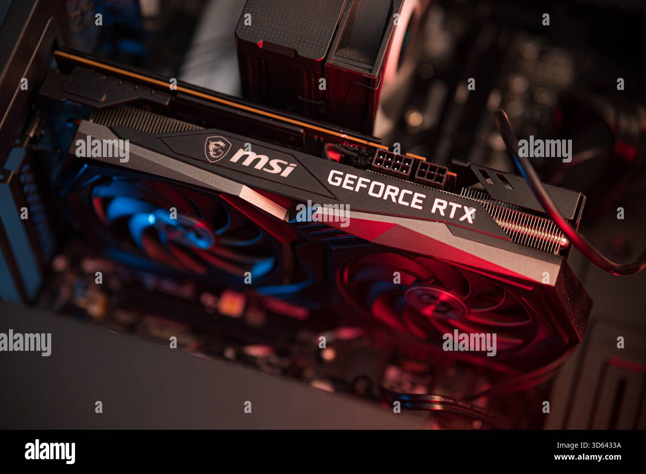 Scheda grafica MSI GeForce RTX, installazione della scheda video in una custodia aperta del PC. Componenti hardware per PC di costruzione o impianti di estrazione mineraria Foto Stock