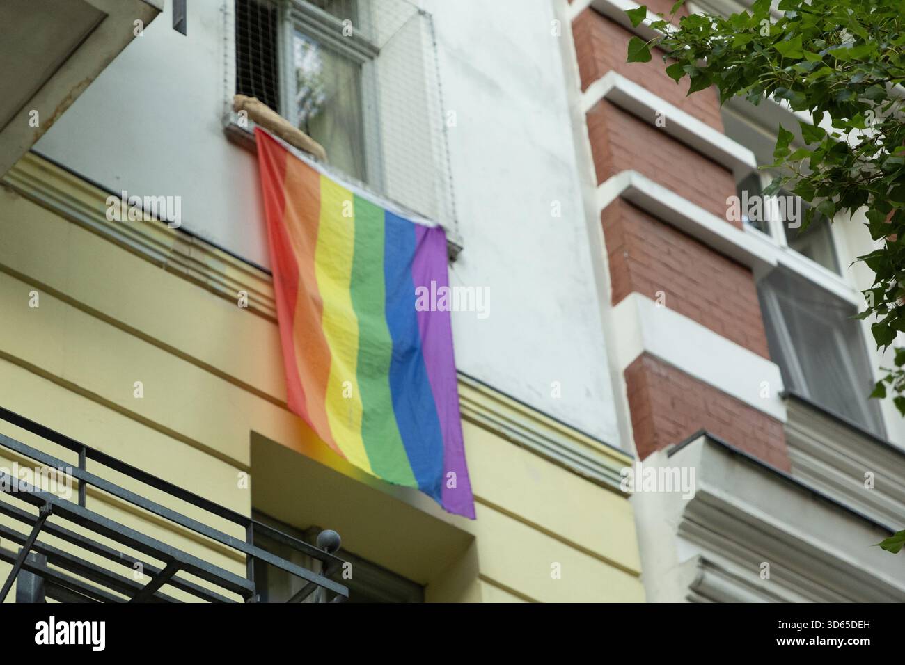 Berlino, Germania - 19 agosto 2025: La bandiera dell'Arcobaleno è esposta dalla finestra dell'edificio urbano della città. Foto Stock