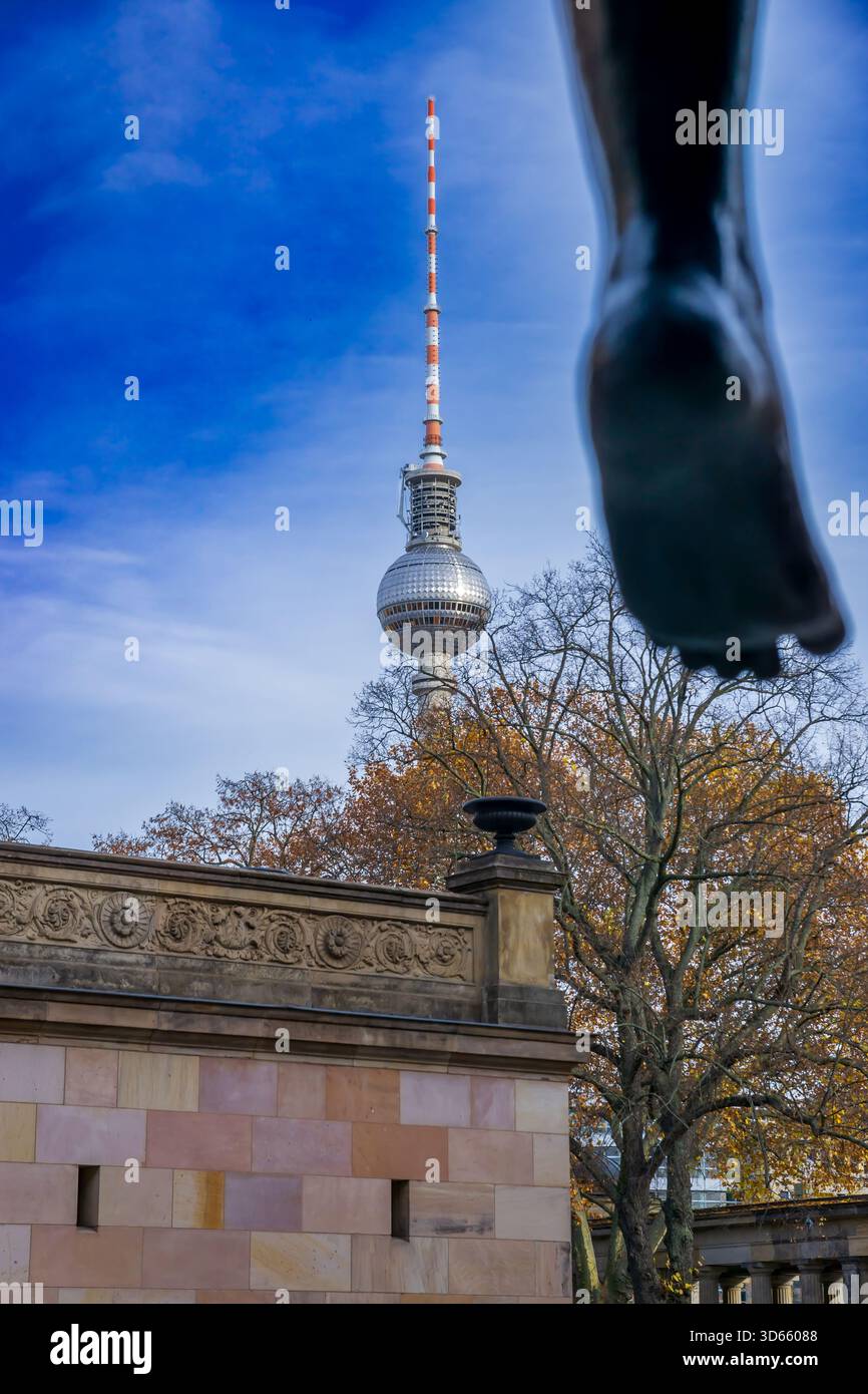 Vista della torre della televisione di Berlino (Fernsehturm) vista dall'Isola dei Musei, incorniciata dai piedi della scultura "Amazone zu Pferde" di Louis Tuaillon, Germania. Foto Stock