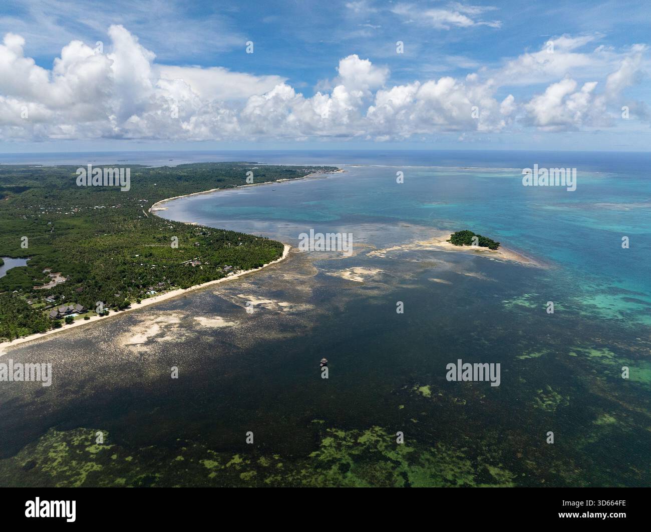 Laguna costiera tropicale con ampio litorale, vegetazione verde e piccola isola. Siargao, Filippine. Foto Stock