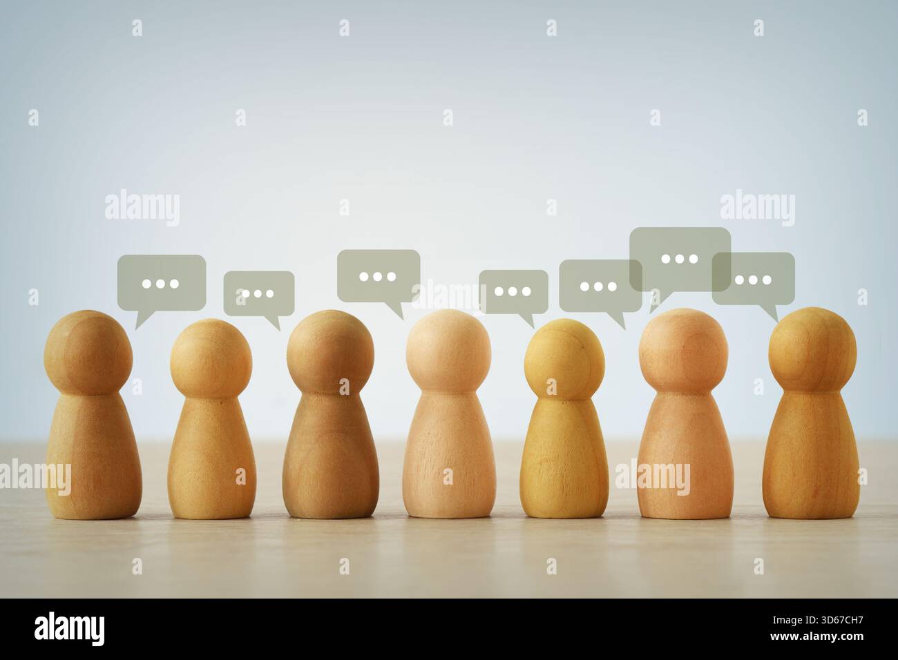 Grupo di pedine di legno con bolle di voce - concetto di comunicazione e diversità Foto Stock