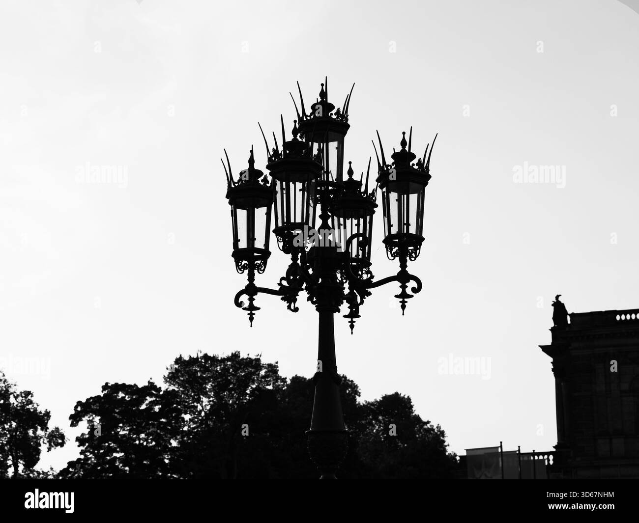 Silhouette di una storica lanterna di strada vicino al Semperoper a Dresda contro il cielo nuvoloso. Foto in bianco e nero. Copyspace. Foto Stock
