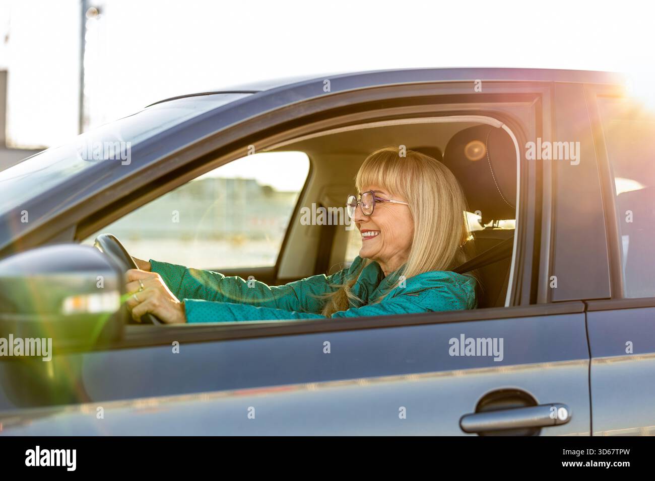 Donna matura che sorride al volante Foto Stock