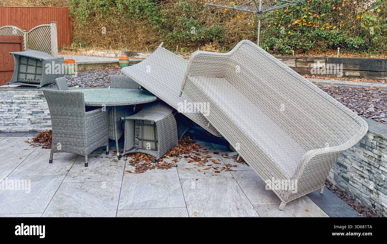 I mobili da giardino in rattan si sono accumulati dopo l'impatto dei venti molto forti di una tempesta. Niente persone. - Immagine stock catturata con smartphone