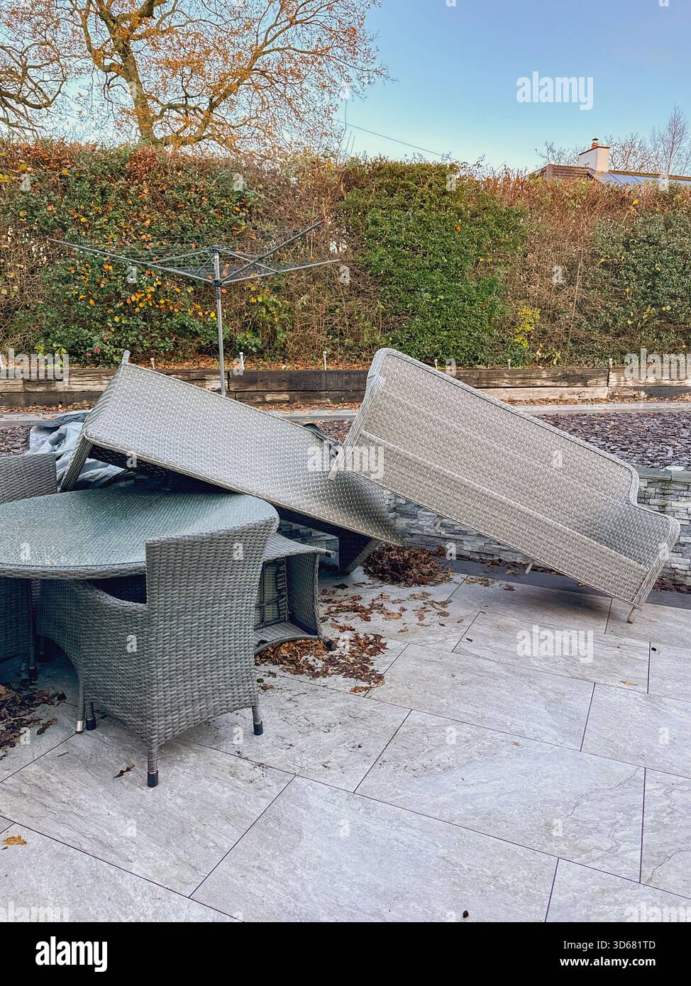 I mobili da giardino in rattan si sono accumulati dopo l'impatto dei venti molto forti di una tempesta. Niente persone. - Immagine stock catturata con smartphone