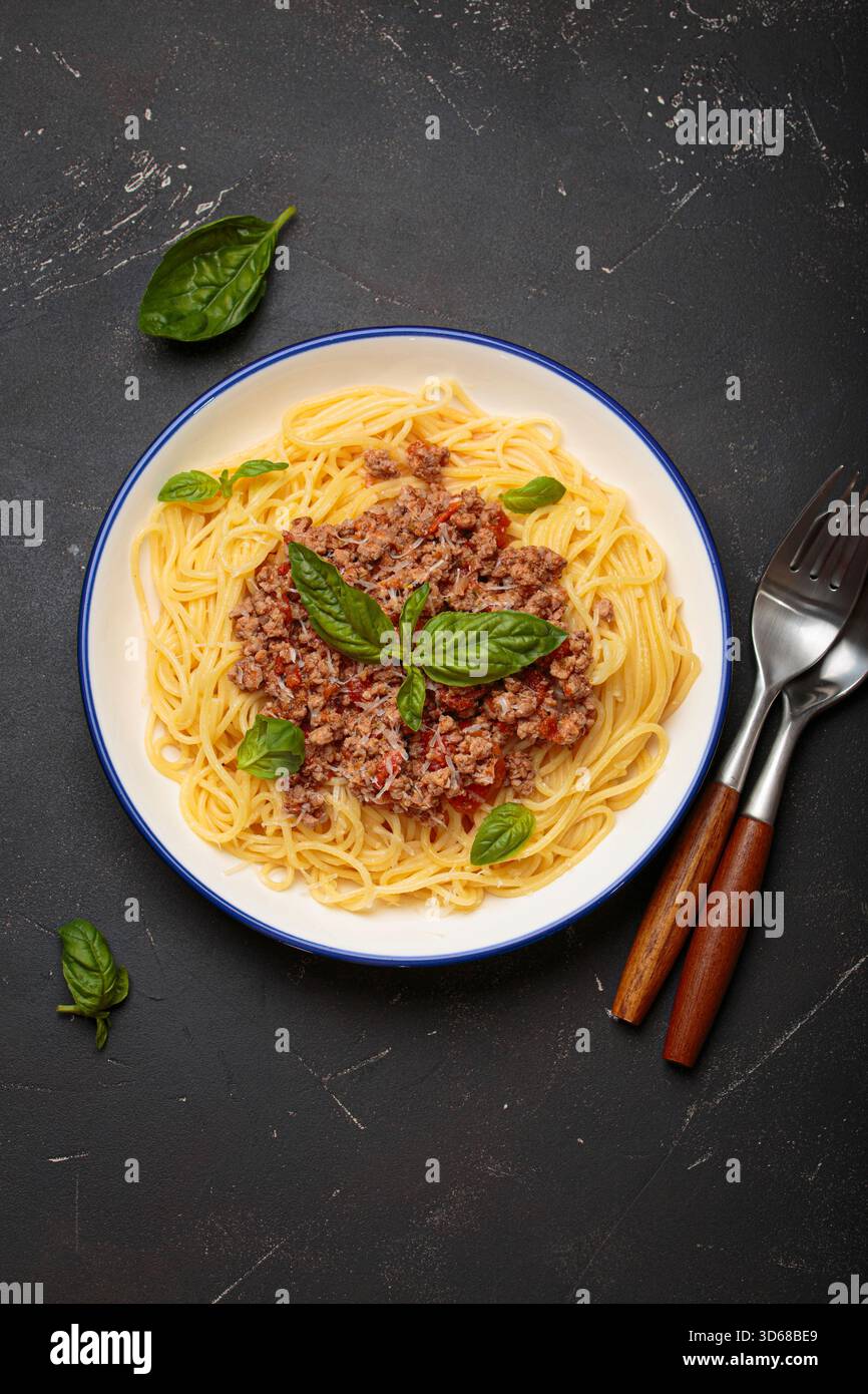 Spaghetti alla bolognese con basilico e parmigiano grattugiato Foto Stock