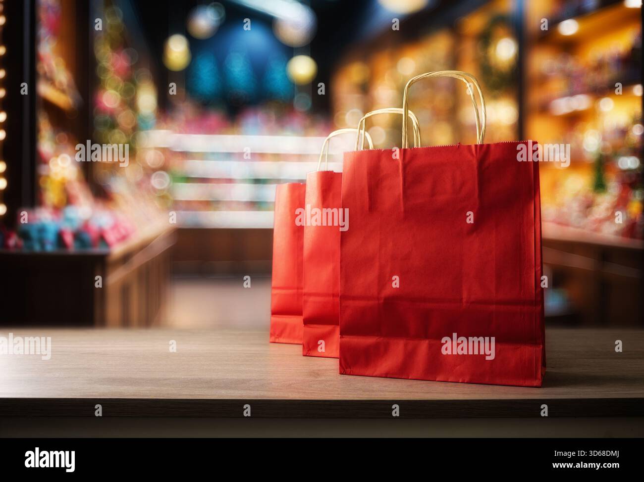 Concetto di shopping nei negozi con sacchetti di carta regalo rossi su una panchina di legno in un negozio di giocattoli e caramelle. Vista frontale. Foto Stock