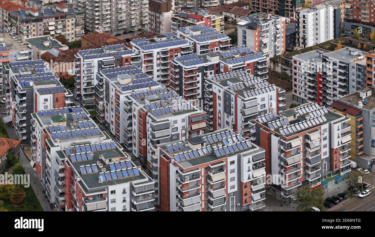 Primo piano aereo dei moderni edifici residenziali di Korçë con tetti a pannelli solari, balconi e una fitta architettura urbana. Foto Stock
