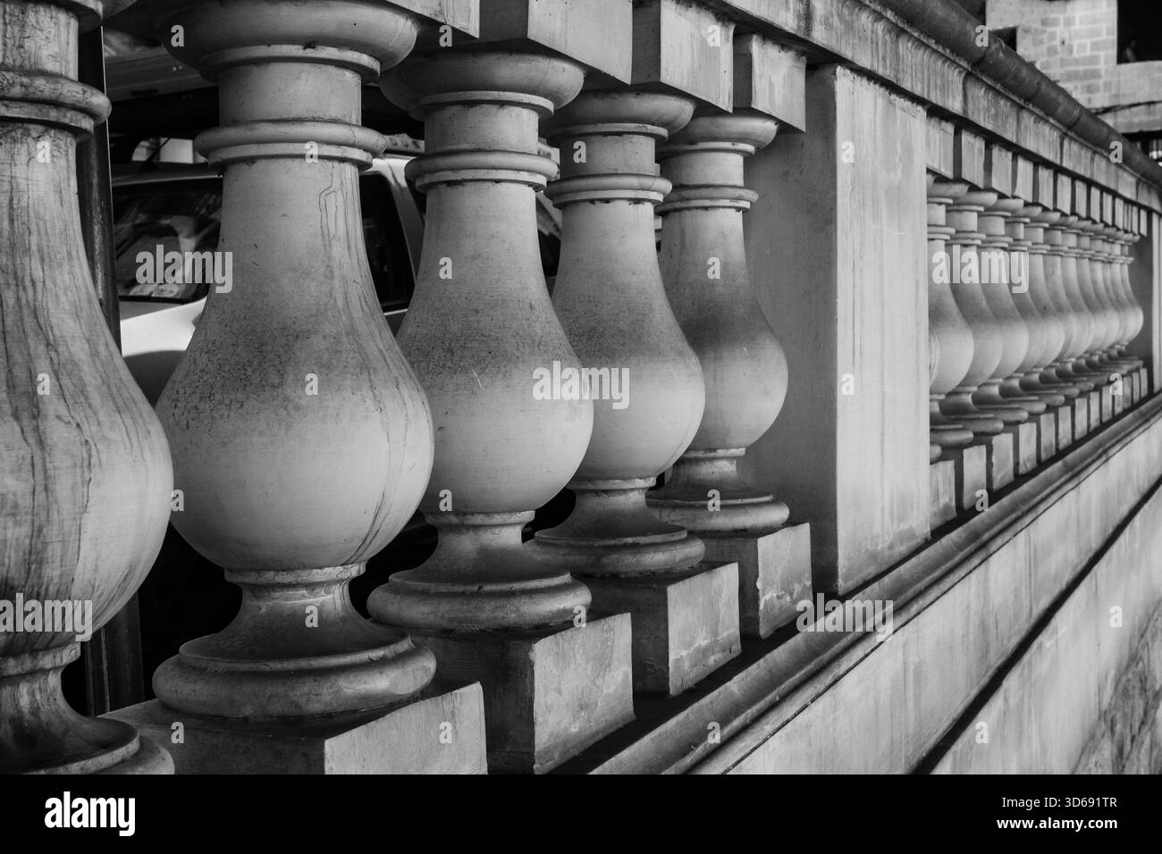 Ringhiere in pietra bianca e nera lungo un muro con terrazza classica in monocromo Foto Stock