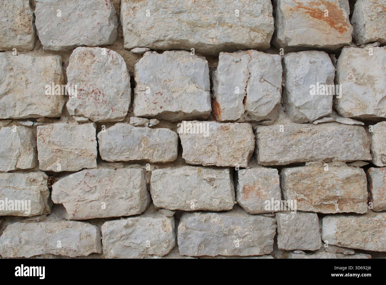 Primo piano ad alta risoluzione di un muro di pietra impilato, texture ruvide e naturali, forme irregolari e toni terrosi. Ideale per sfondi antichi, Foto Stock