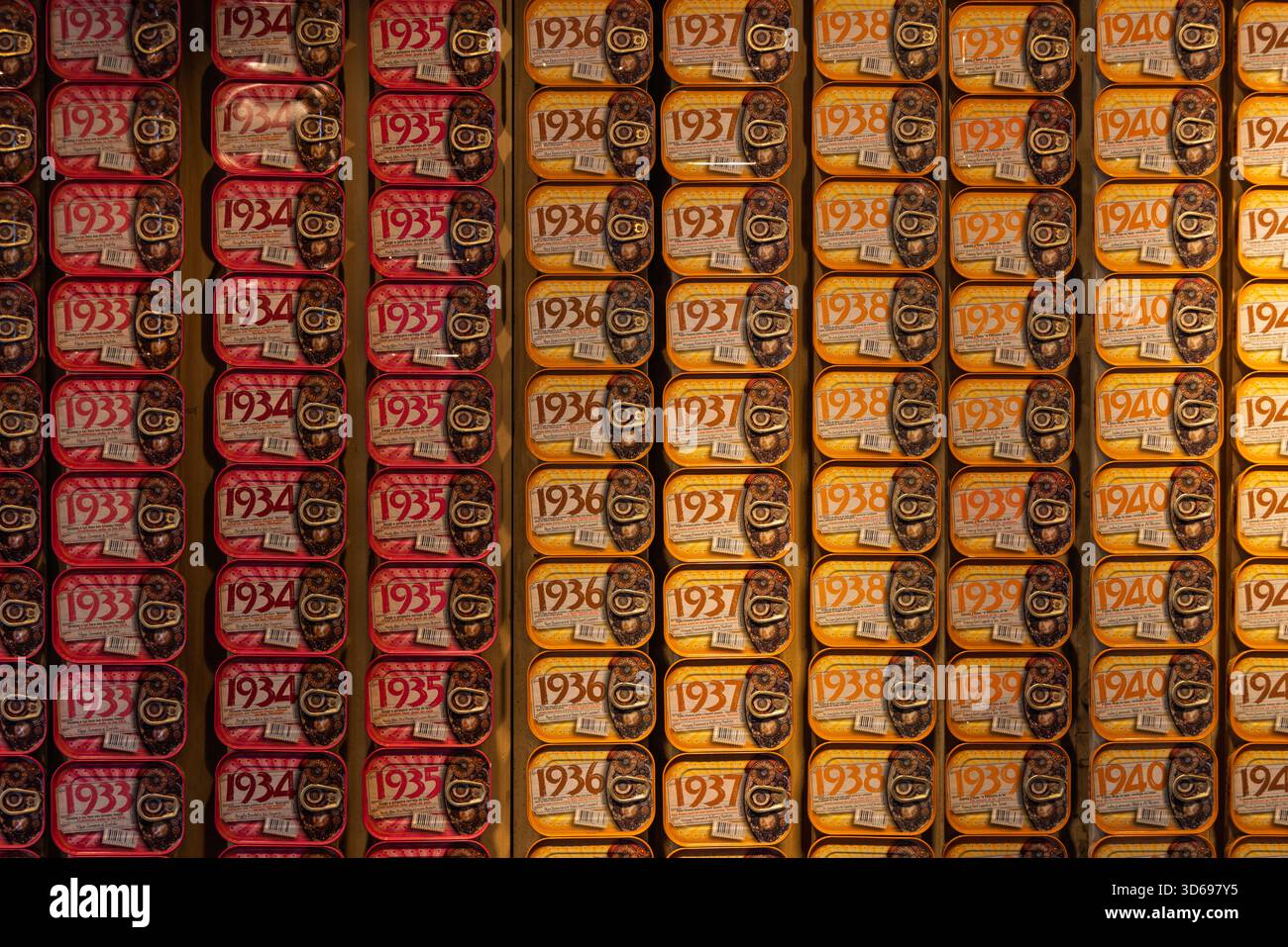 Un'esposizione a parete di barattoli di sardine portoghesi in stile vintage, che mostra file organizzate per anni dagli anni '1930 e '1940 in un negozio. Foto Stock