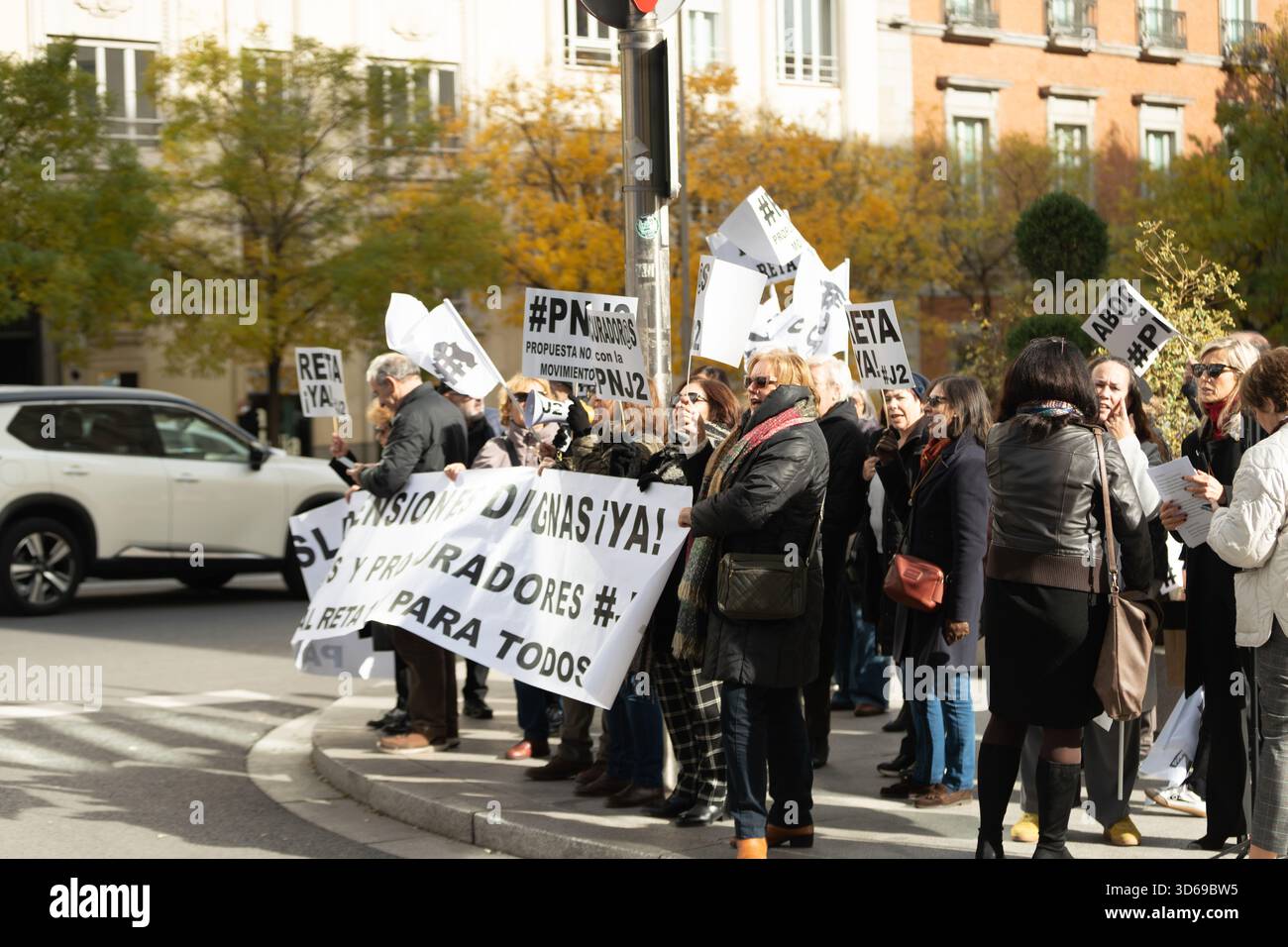 Madrid, Spagna. 19 novembre 2025. I membri del Movimiento #J2 e altri professionisti mutualisti protestano al di fuori del Congresso spagnolo dei deputati a Madrid durante una regolare azione settimanale volta a chiedere un equo «Pasarela al RETA» 1x1 che consenta a avvocati, procuratori e altri mutualisti di trasferire i loro contributi pensionistici al sistema pubblico di sicurezza sociale, denunciando le pensioni future basse e chiedendo giustizia sociale ed economica. Crediti: Diego Martínez/Alamy Live News. Foto Stock