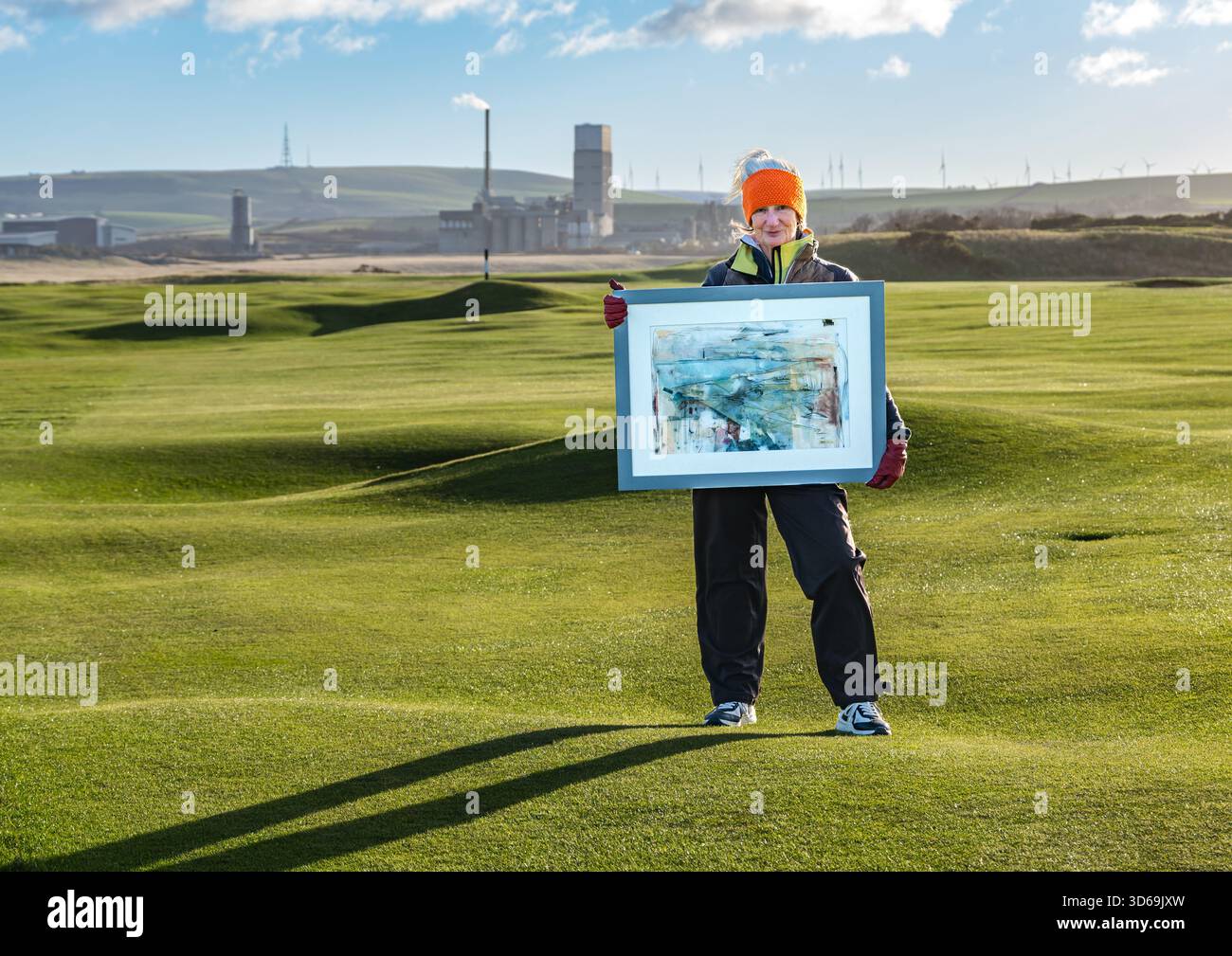Dunbar Golf Course, East Lothian, Scozia, Regno Unito, 19 novembre 2025. Artista Liz McClarty Jones: Il paesaggista Liz è un appassionato golfista e membro del club di golf Dunbar ed è specializzato in paesaggi semi-astratti di campi da golf Links in tutta la Scozia. Posa con una delle sue opere ispirate a questo campo da golf, il giorno più freddo dell'inverno finora, per il progetto del fotografo East Lothian Artists Credti: Sally Anderson/Alamy Live News Foto Stock