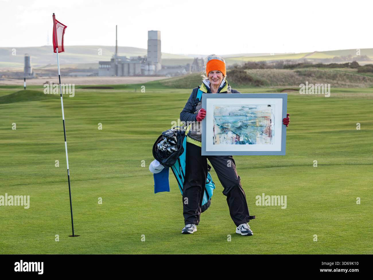 Dunbar Golf Course, East Lothian, Scozia, Regno Unito, 19 novembre 2025. Artista Liz McClarty Jones: Il paesaggista Liz è un appassionato golfista e membro del club di golf Dunbar ed è specializzato in paesaggi semi-astratti di campi da golf Links in tutta la Scozia. Posa con una delle sue opere ispirate a questo campo da golf, il giorno più freddo dell'inverno finora, per il progetto del fotografo East Lothian Artists Credti: Sally Anderson/Alamy Live News Foto Stock