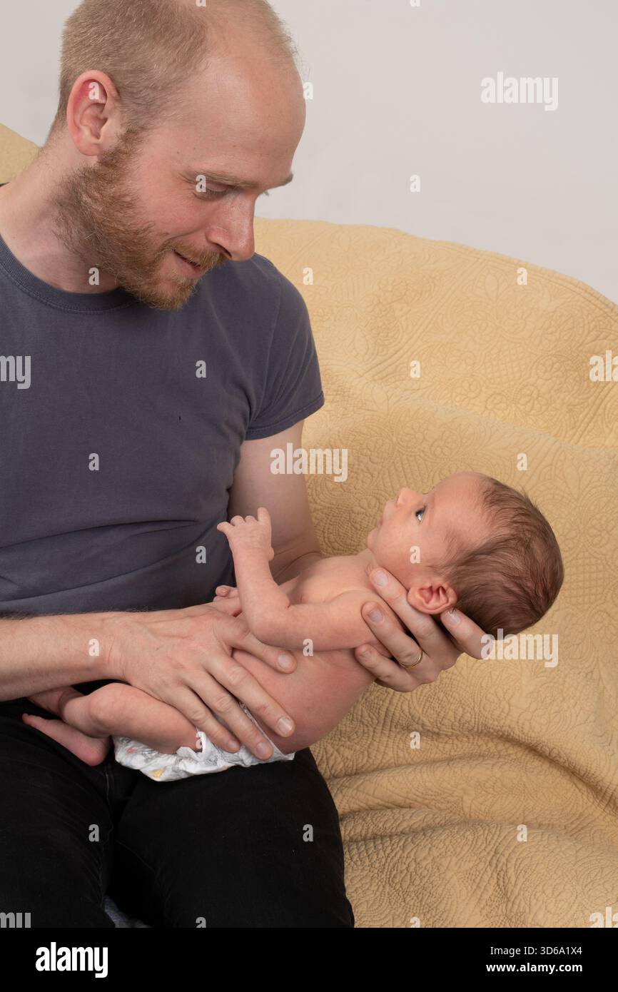 Bambino appena nato, di 3 settimane con il padre, trattenuto Foto Stock
