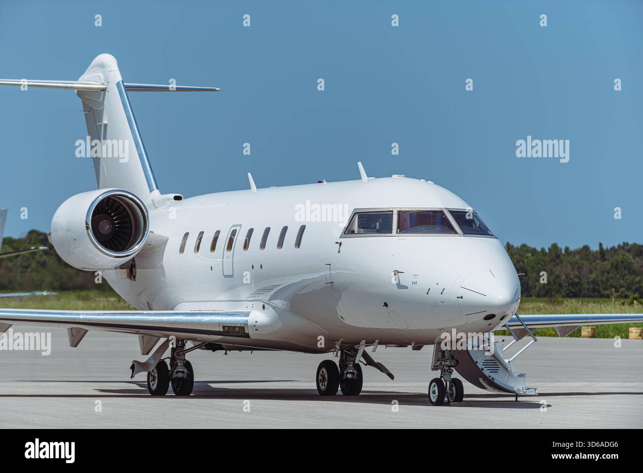 Vista laterale dell'aereo business jet bimotore bianco parcheggiato sull'asfalto dell'aeroporto. Aeromobili che presentano finestre di pilotaggio, finestre della fusoliera, ali di coda, Foto Stock