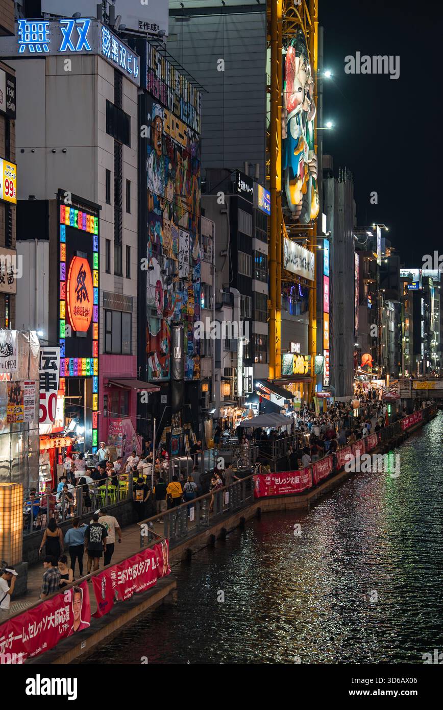 Vita notturna lungo il Canale Dotonbori con ruota panoramica Don Quijote Foto Stock