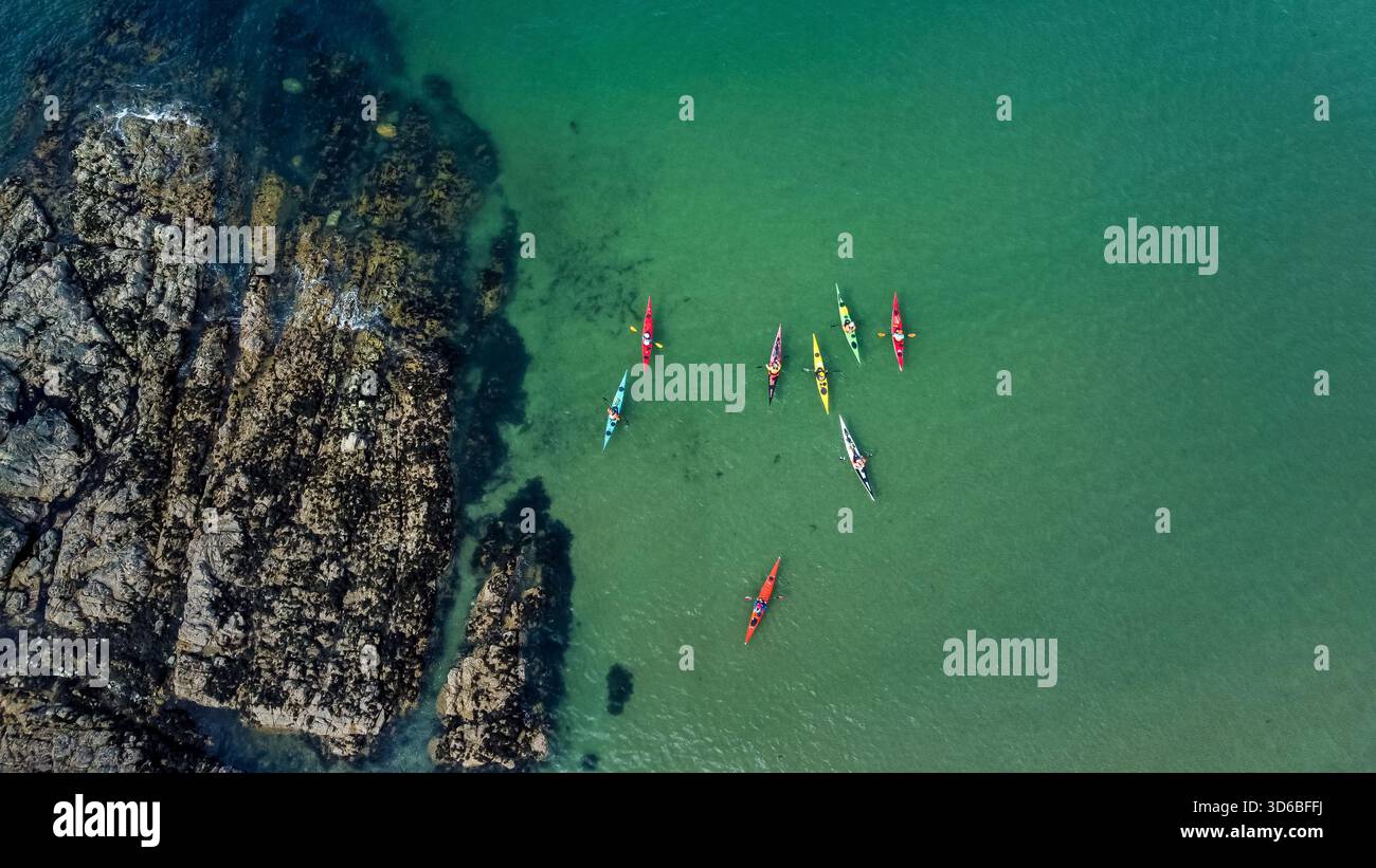 Veduta aerea dei kayak che pagaiano accanto ai fondali rocciosi della costa Foto Stock