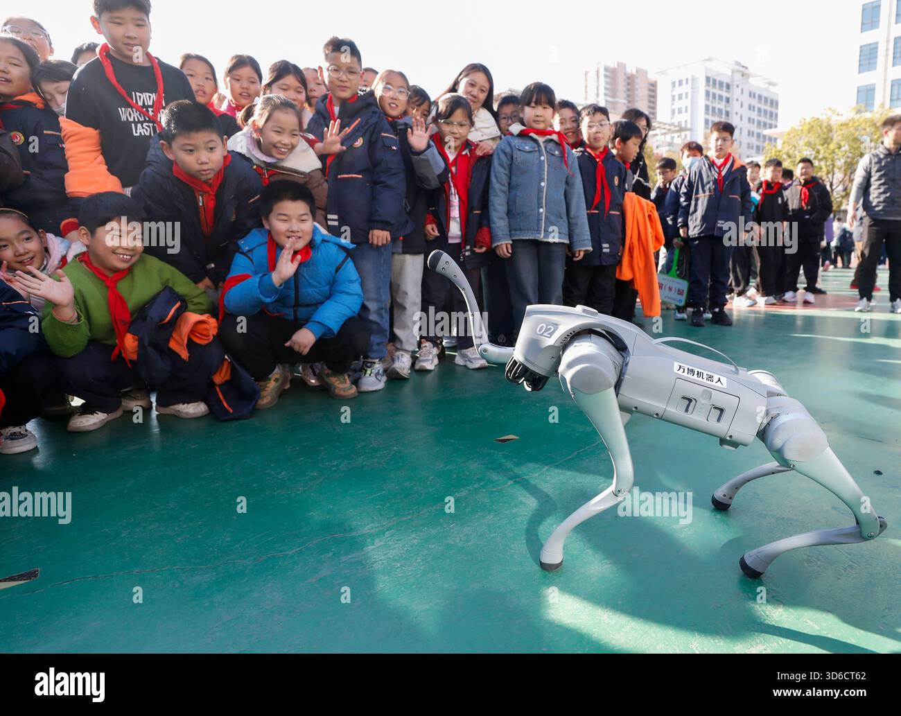 Gli studenti delle scuole elementari interagiscono con un cane robotico nella città di Huai'an, provincia di Jiangsu, Cina, il 20 novembre 2025. Foto Stock