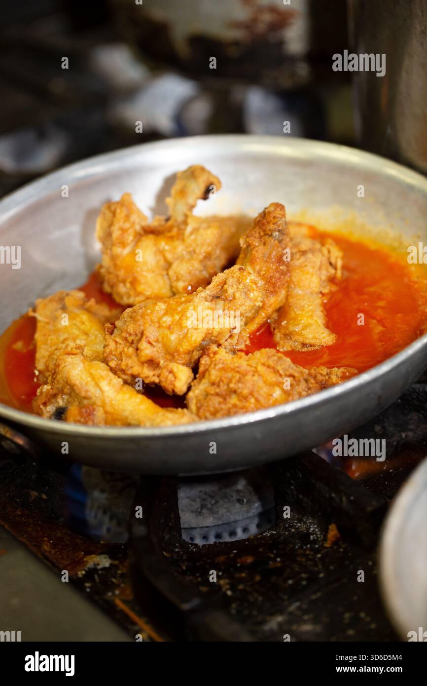 Vista delle ali di pollo che cucinano in una padella. Foto Stock