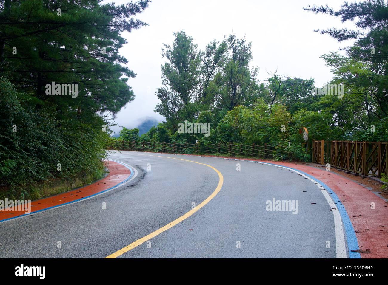 L'area di sosta di Ihwaryeong si trova sotto i pini al passo di Ihwa, il suo edificio con tetto piastrellato illuminato da corde di lampadine accanto a un chiosco di distributori automatici e un parcheggio a poppa Foto Stock