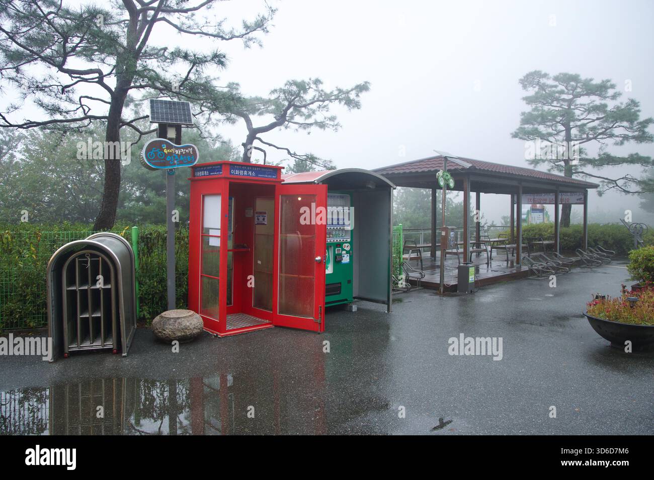 Accanto al gazebo in cima, lo stand di certificazione rosso di Ihwaryeong e un distributore automatico adiacente servono i ciclisti al passo di Ihwa, con portabiciclette e W Foto Stock