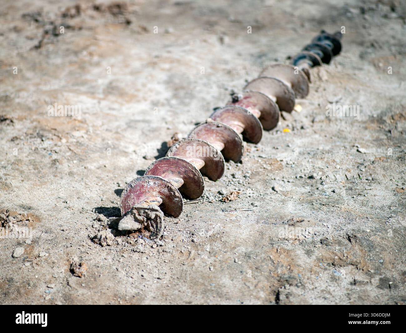 vecchio trapano arrugginito abbandonato per terra, nessuna gente, un colpo alla luce del giorno Foto Stock