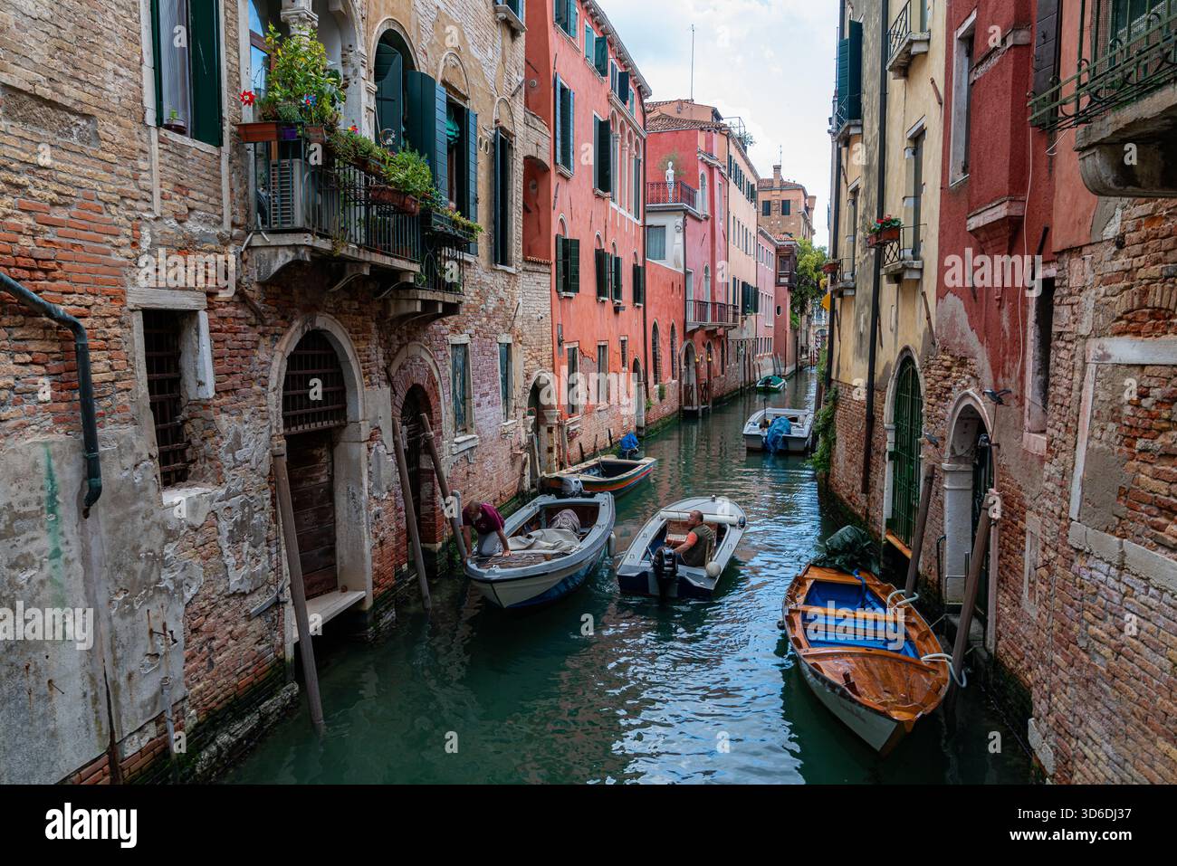 La stretta via di Venezia, il canale. Barche sull'acqua, suggestiva scena della città vecchia, ideale per viaggi, architettura e fotografia di strada. Foto Stock
