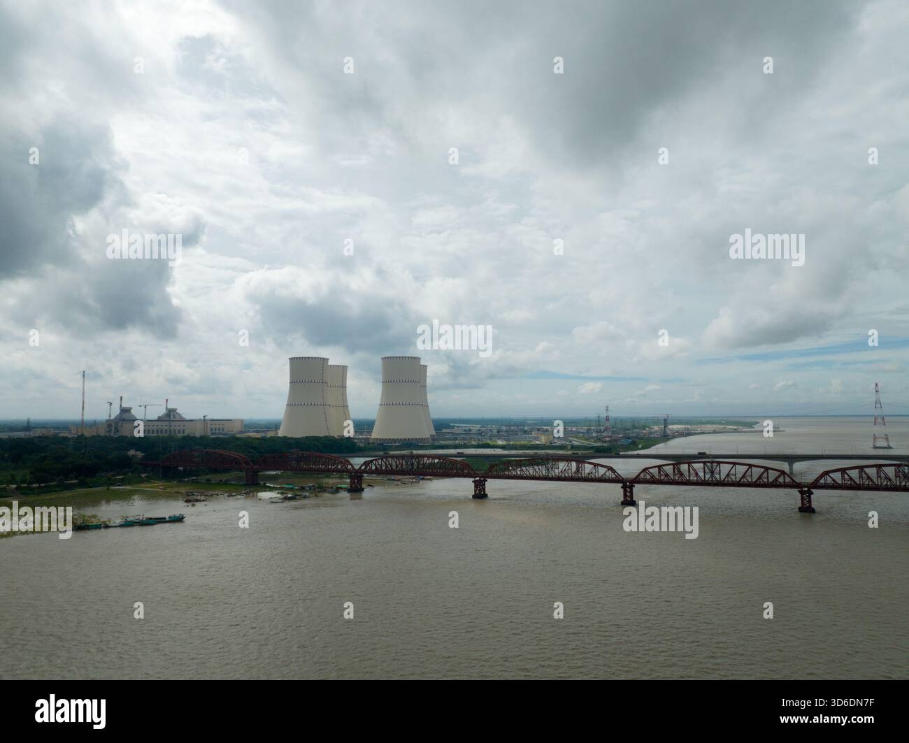 Veduta aerea del ponte che si estende sul fiume fangoso verso l'impianto nucleare sullo sfondo di un cielo nuvoloso, Ruppur, divisione Rajshahi, Foto Stock